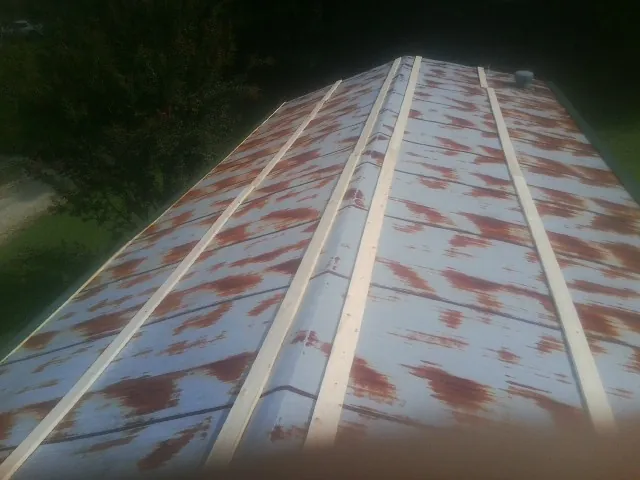 Rusted metal roof panels with new wood purlins before replacement — Storm Damage Roof Repair in Valley Falls by Roofing Brothers