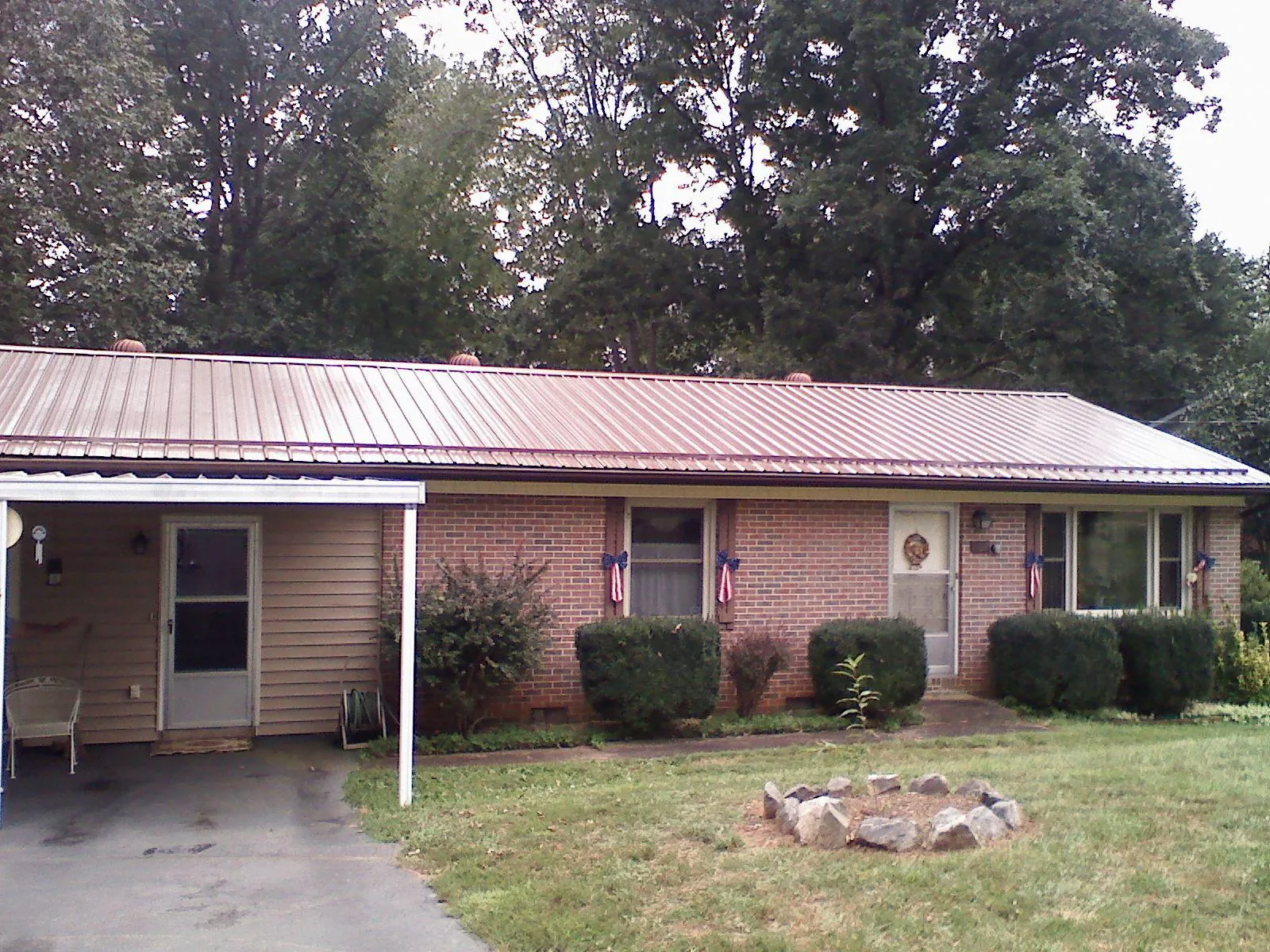 Bronze metal roof and carport on a brick ranch home — Roof Repair work by our crew in Valley Falls