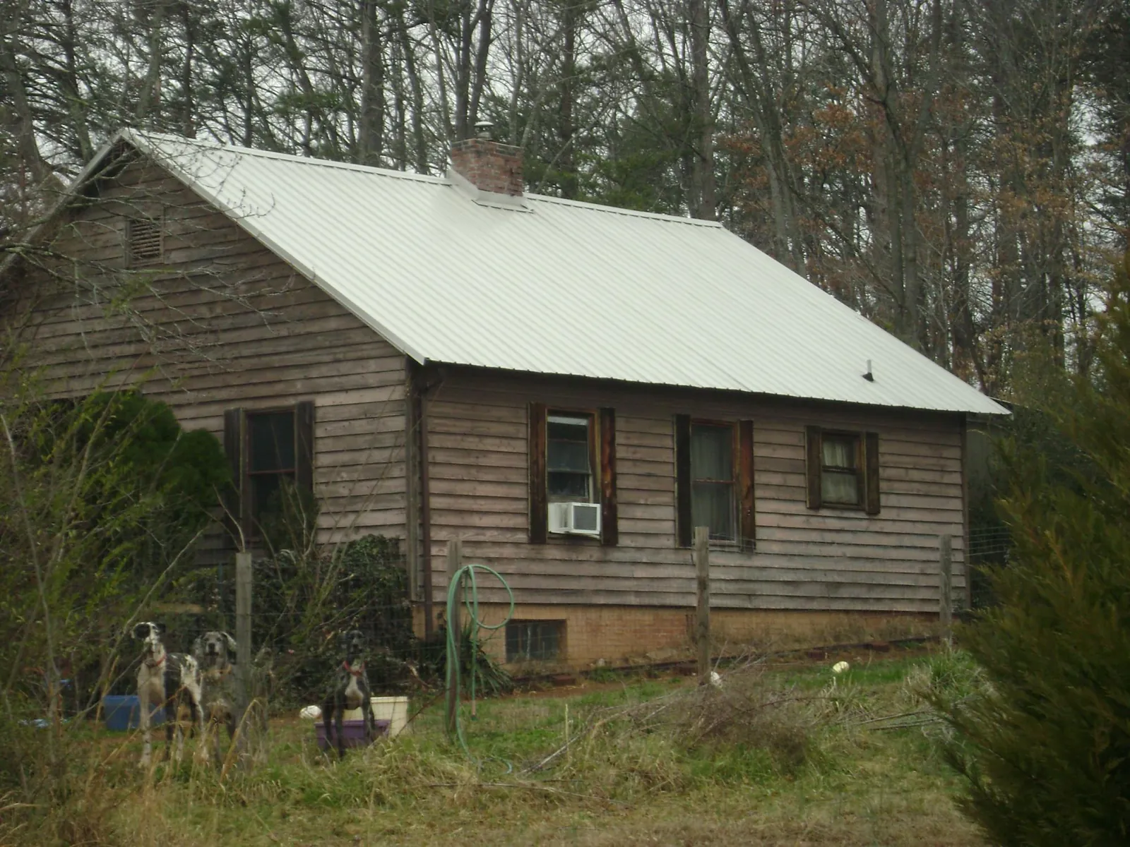 White metal roof on an old wood sided farmhouse, from a Metal Roof Installation job in Valley Falls