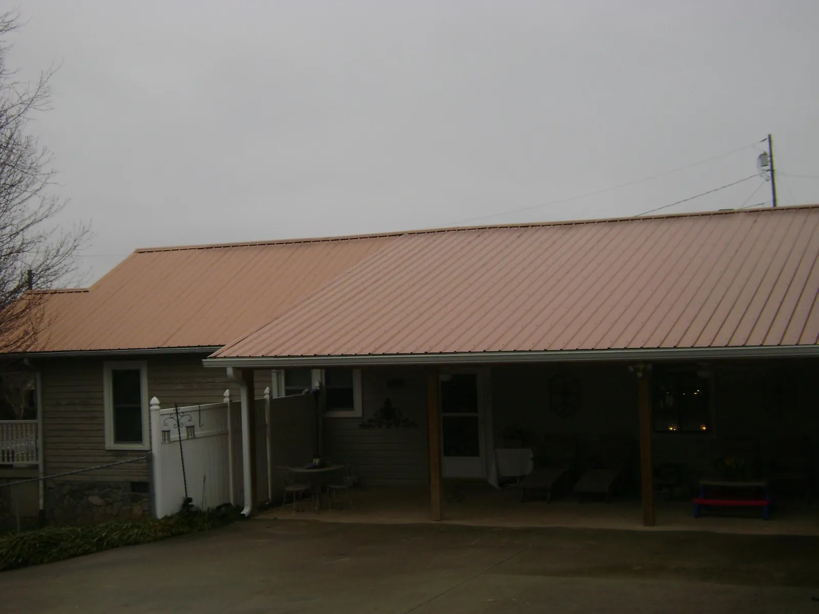 Copper toned metal roof over a wide covered patio in Valley Falls